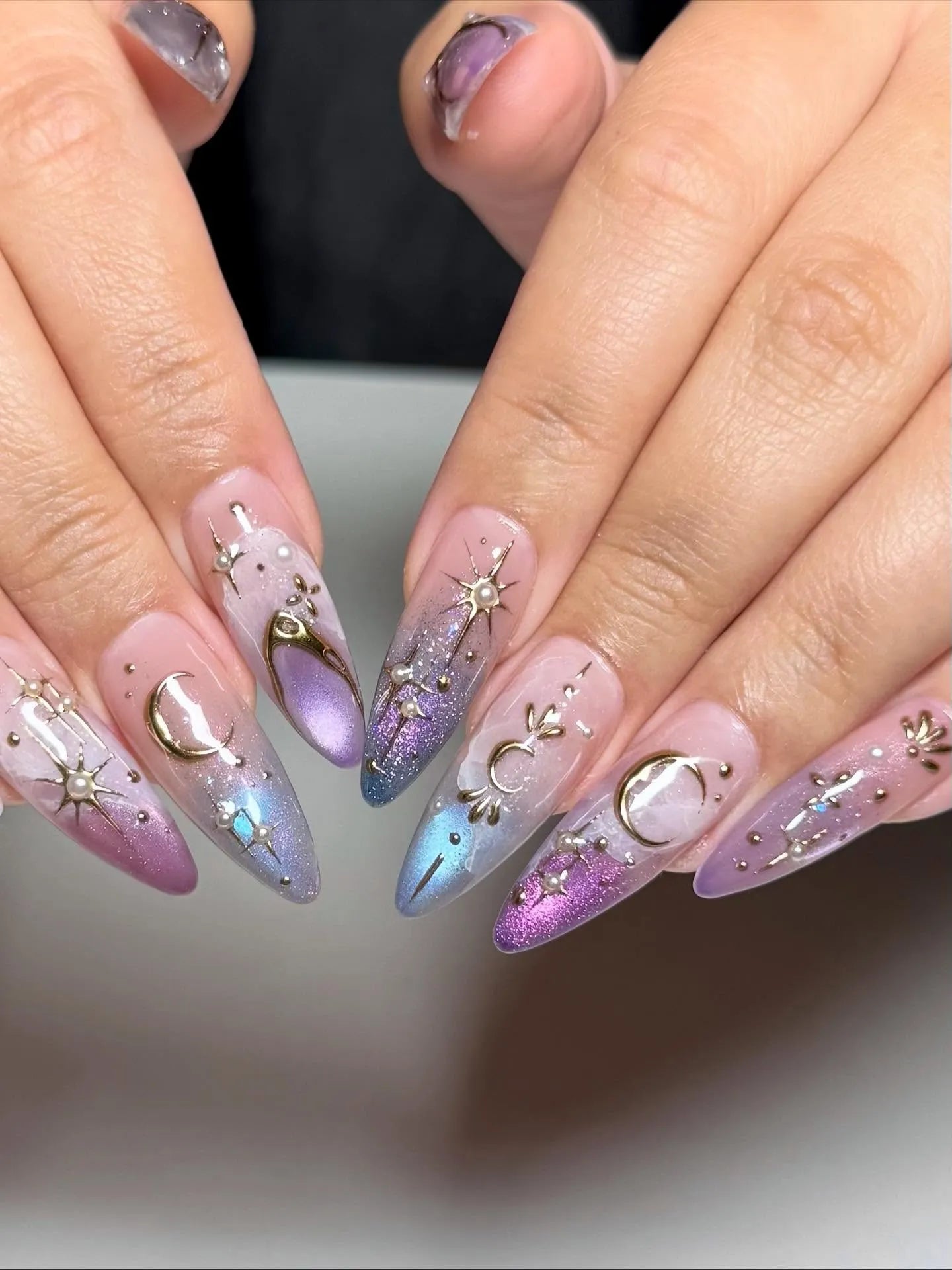 Handmade iridescent stiletto press-on nails with celestial moon and star gold accents