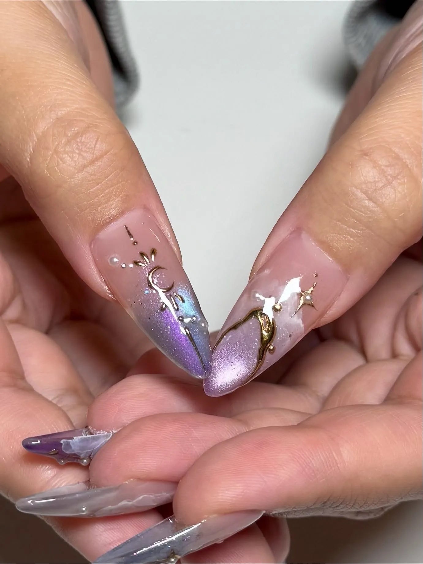 Handmade iridescent stiletto press-on nails with gold moon and star celestial designs