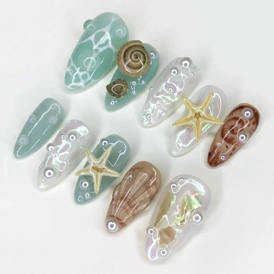 Handmade iridescent seafoam press-on nails with shells, starfish, and ocean-inspired accents