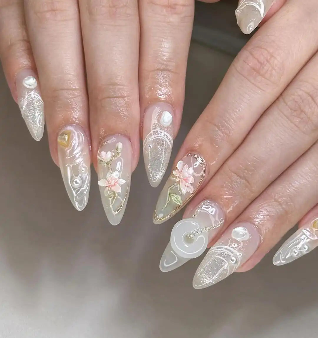 Handmade 3D press-on nails with glitter, pearl accents, floral designs, and cat eye effect