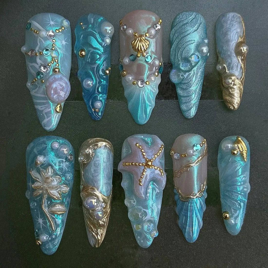 Handmade blue press-on nails with mermaid, starfish, shell, and pearl fantasy designs