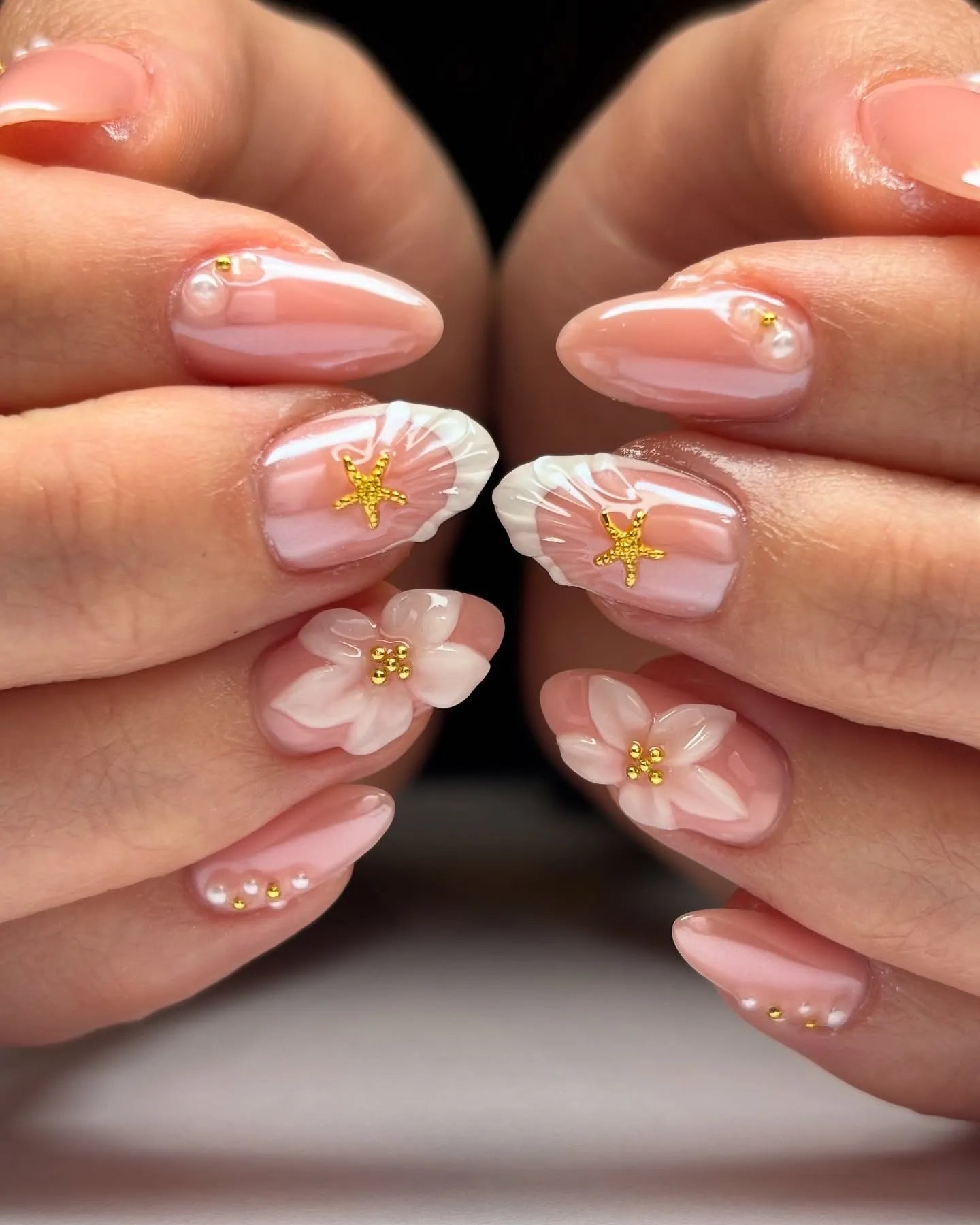 Handmade press-on nails with 3D white flowers, gold star accents, pearl details, and a glossy finish