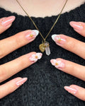 Handmade press-on nails with pink base, 3D white flowers, gold star accents, and pearl details