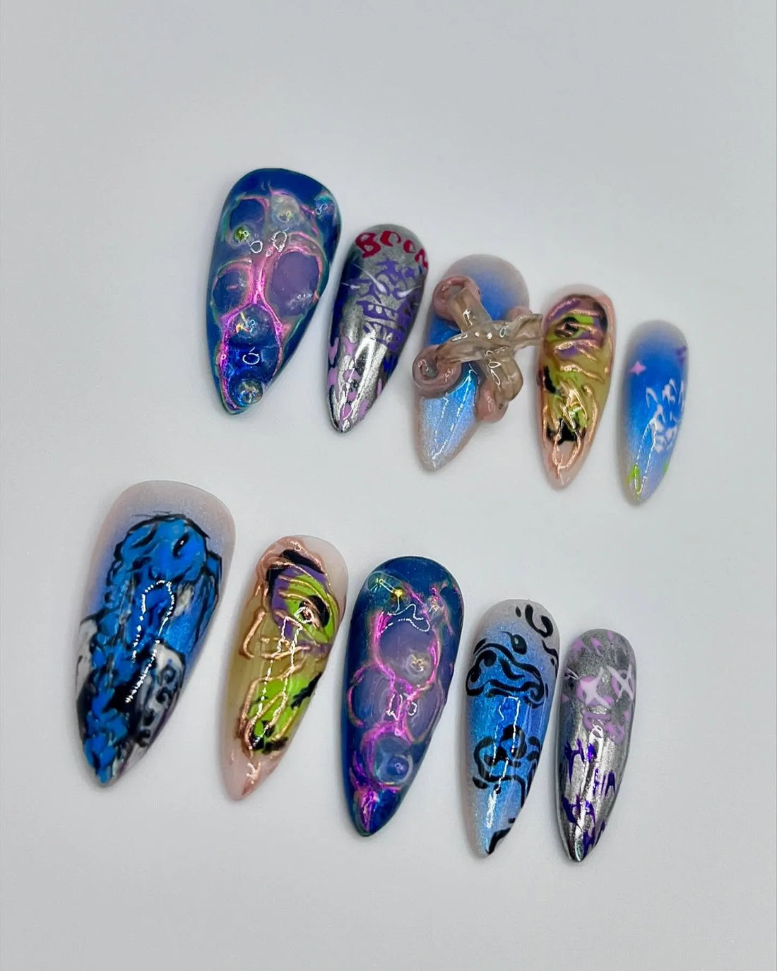 Handmade press-on nails with neon blue, chrome, abstract and grunge digital art designs.