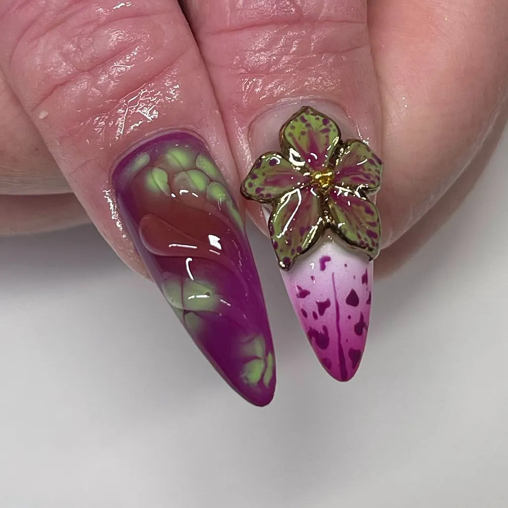 Handmade press-on nails with neon green, pink, and purple abstract drip design and 3D flower accent