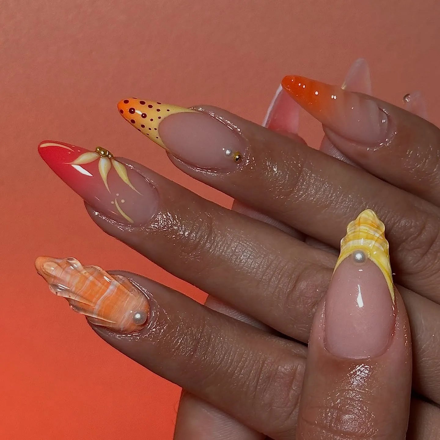 Handmade neon orange and pink mismatched butterfly and shell press-on nails with summer abstract designs.