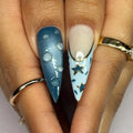 Ocean blue ombre press-on nails with 3D swirl and gold star sky designs on long stiletto tips