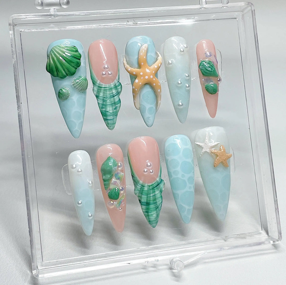 Handmade ocean green press-on nails with 3D shell, starfish, and pearl beach designs.