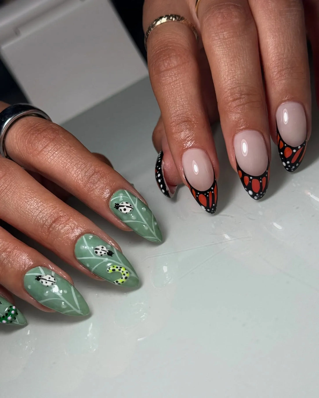 Handmade press-on nails with orange monarch butterfly and green beetle nature designs