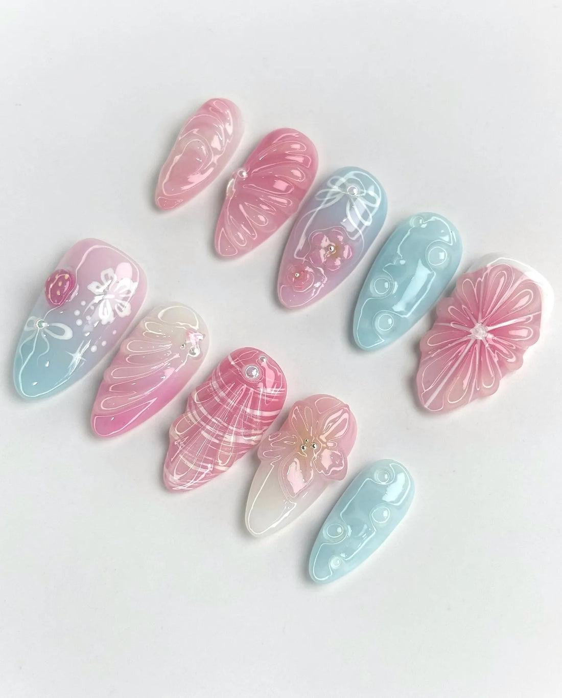 Handmade pastel pink and blue 3D floral sculpted shell press-on nails with glossy finish.
