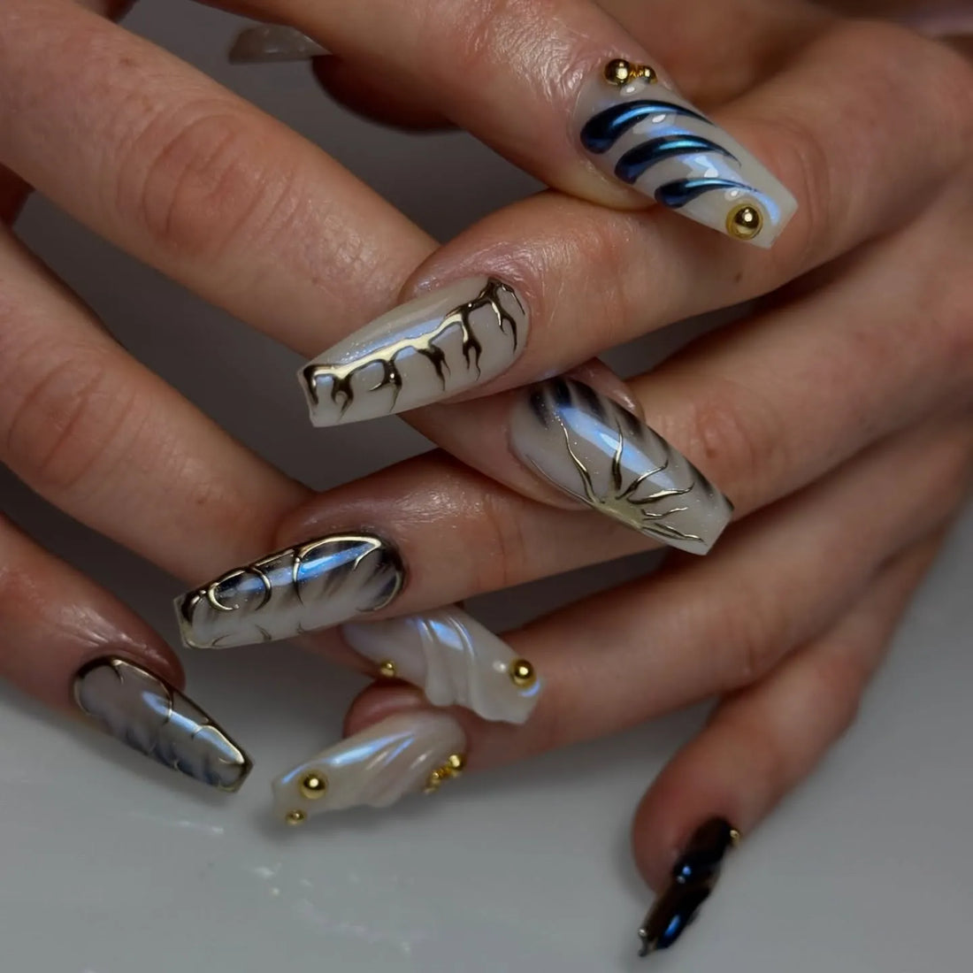 Handmade pearl white 3D swirl gold studded press-on nails with modern abstract design