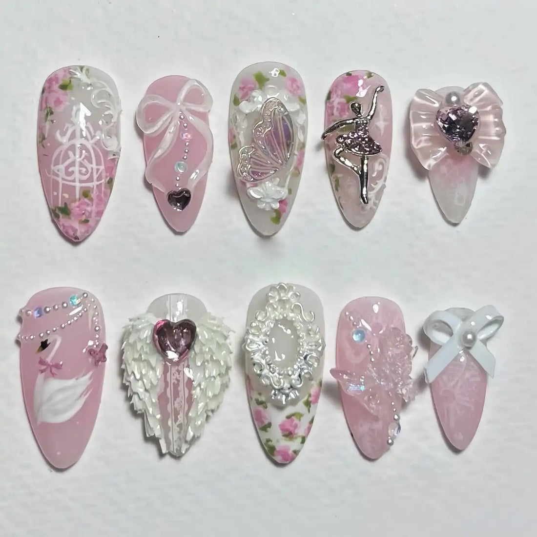 Handmade pink press-on nails with ballerina, swan, butterfly, bows, florals, and 3D accents.