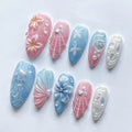 Handmade press-on nails with pink and blue jellyfish, seashell, and floral mermaid designs.