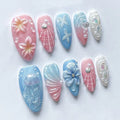 Handmade press-on nails with pink, blue, and white seashell, floral, and jellyfish designs.