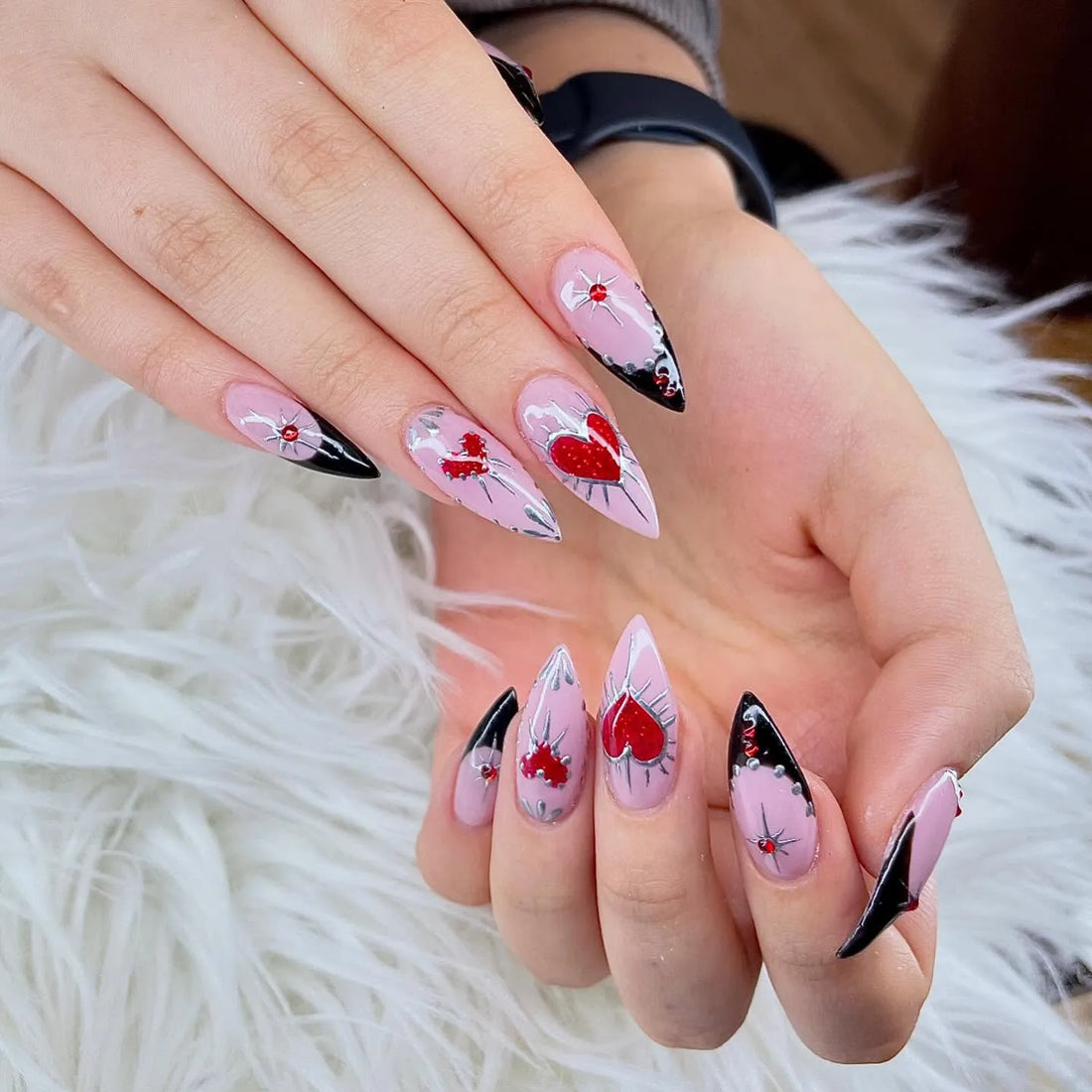 Handmade pink press-on nails with red heart, spike, and black chrome goth designs