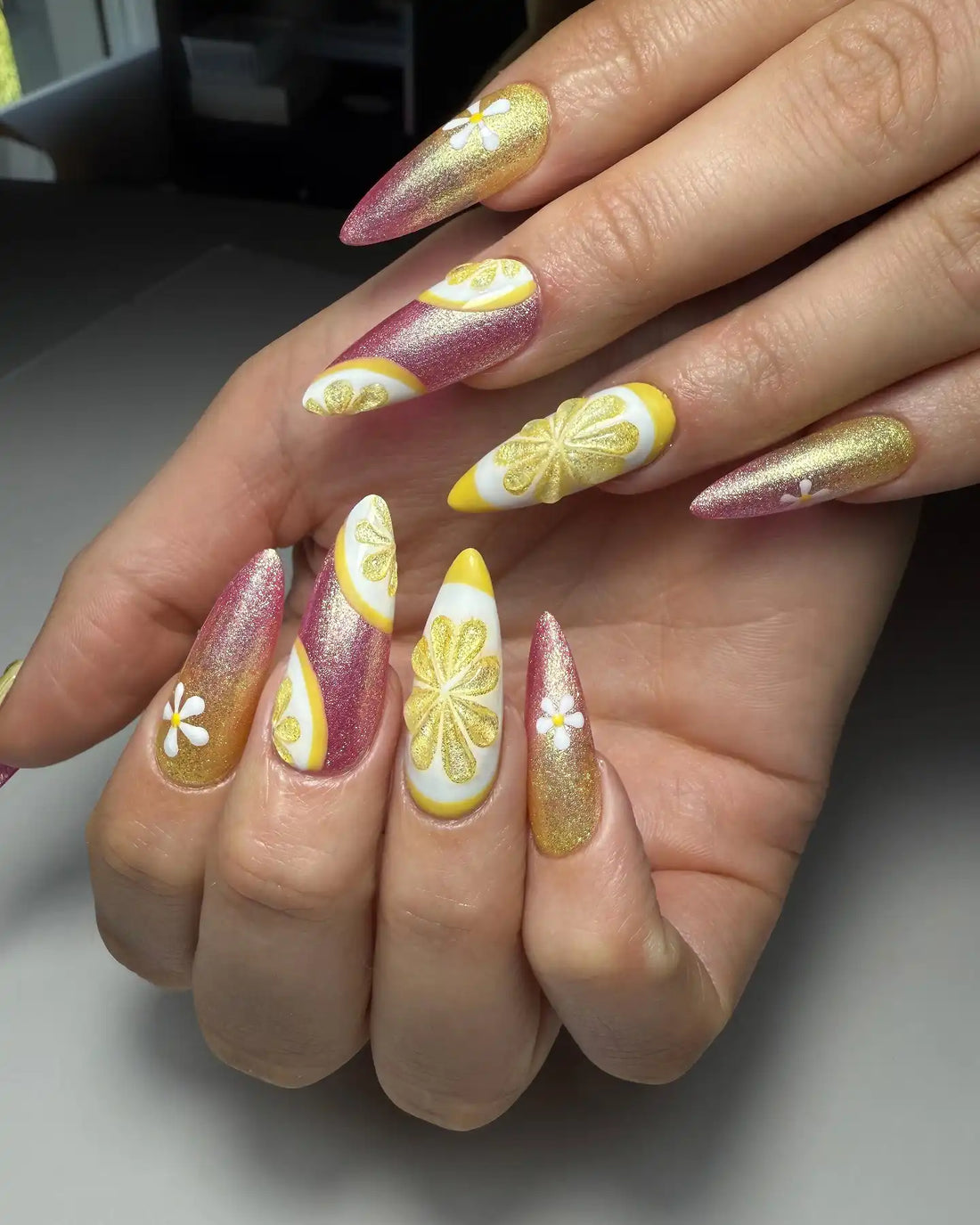 Handmade stiletto press-on nails with pink, gold, and lemon citrus nail art accents.