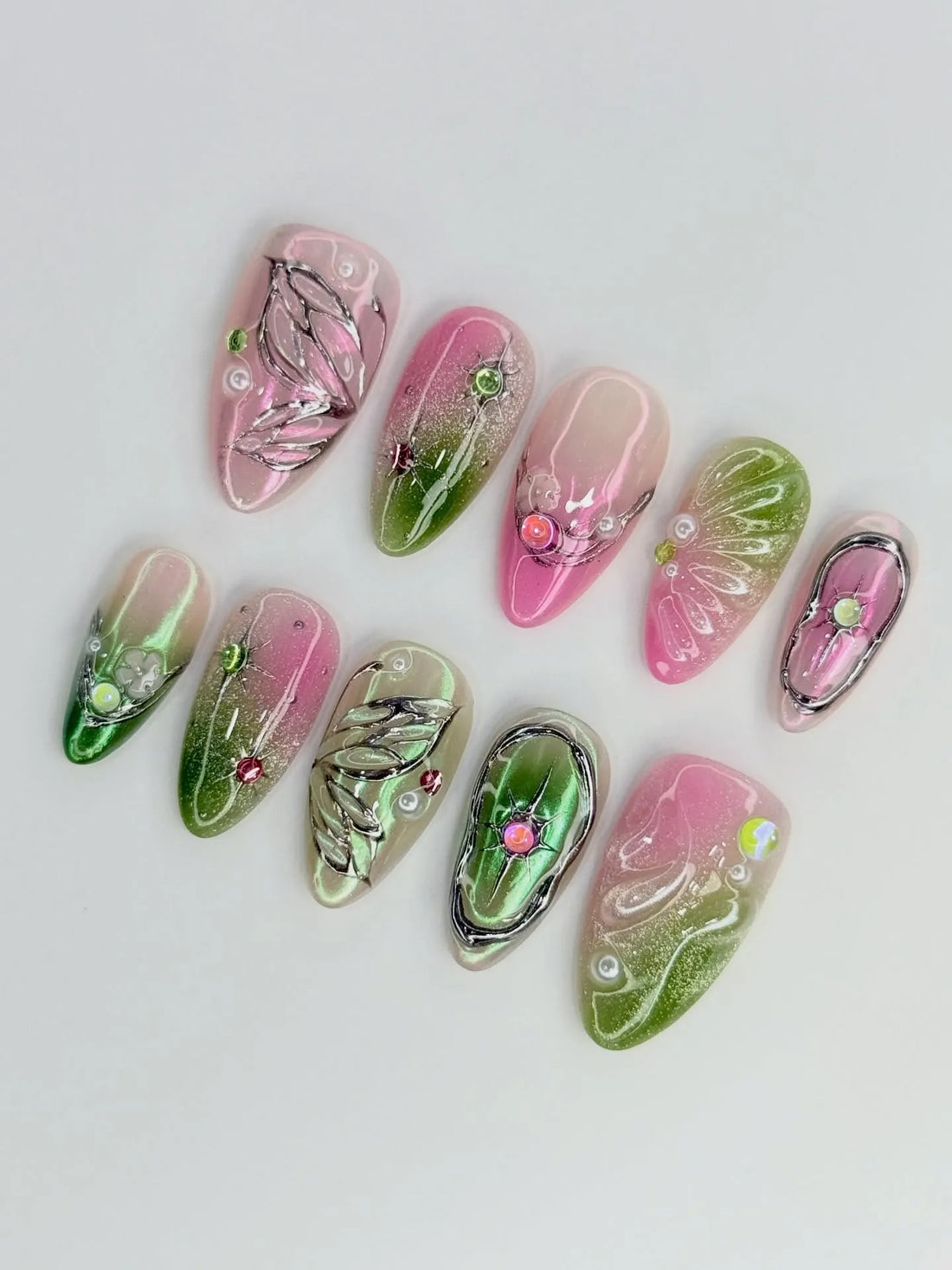 Handmade pink and green butterfly wing press-on nails with chrome details and gem accents.