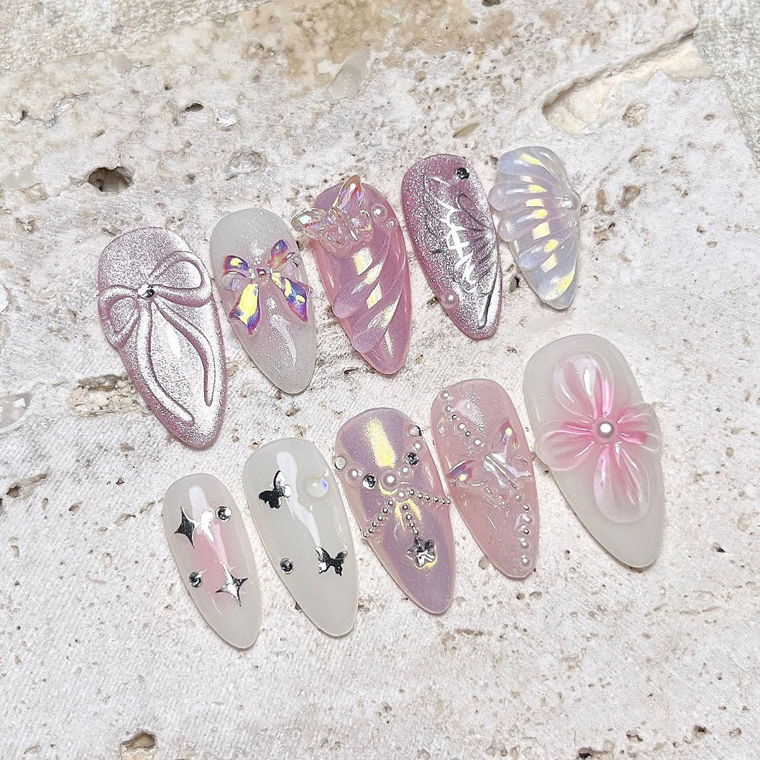 Handmade pink mermaid press-on nails with butterfly, seashell, pearl, and floral 3D designs.