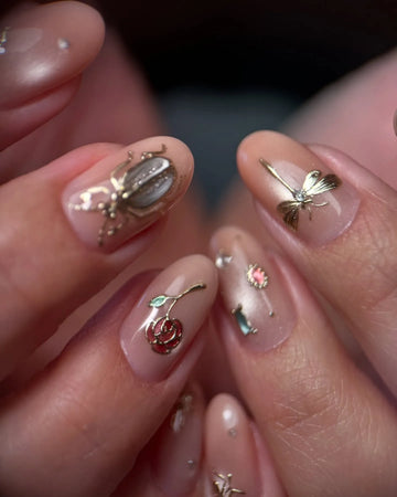 Handmade pink nude press-on nails with gold insect, dragonfly, rose, and gemstone accents