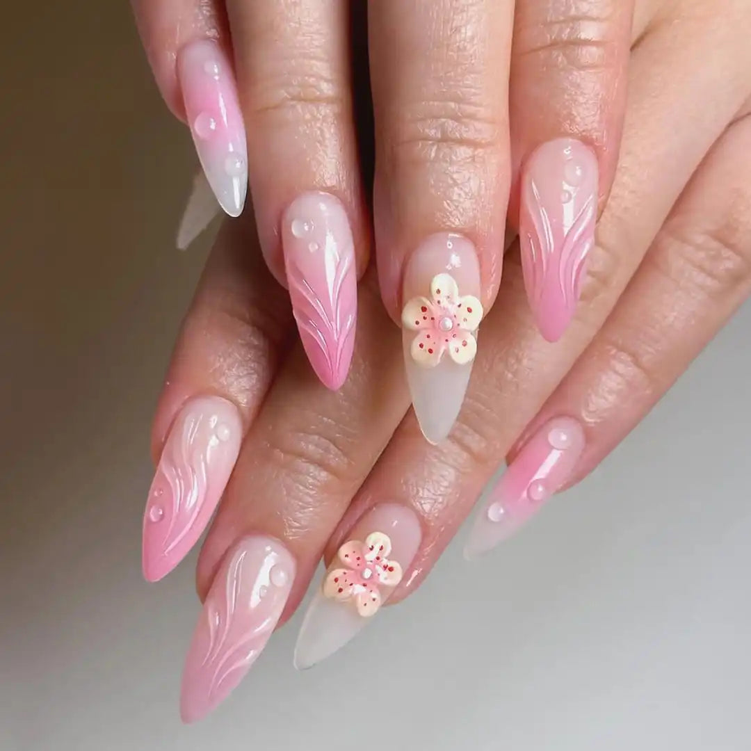 Handmade pink ombre press-on nails with yellow 3D flower and pearl accents, almond shape