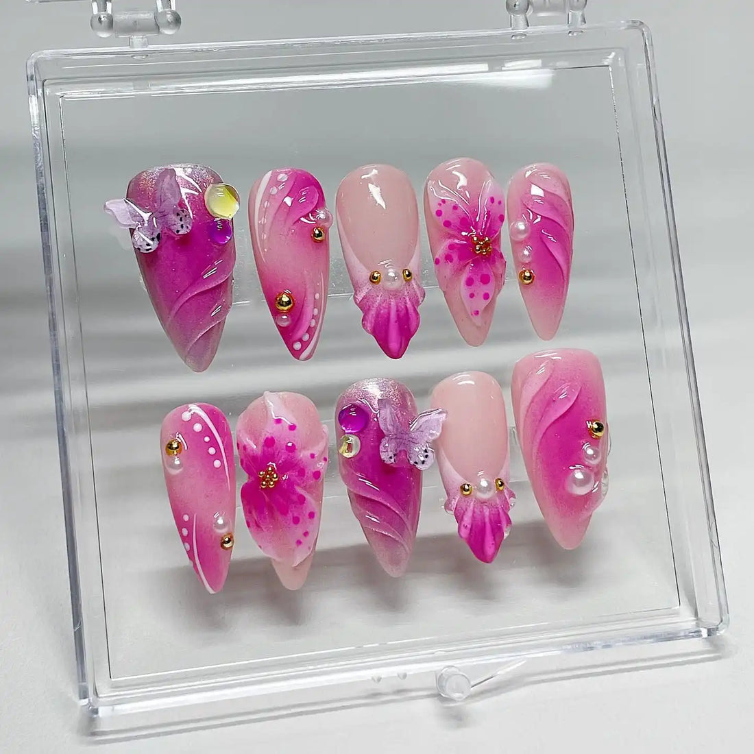 Handmade pink and purple floral butterfly press-on nails with gold studs and pearls.