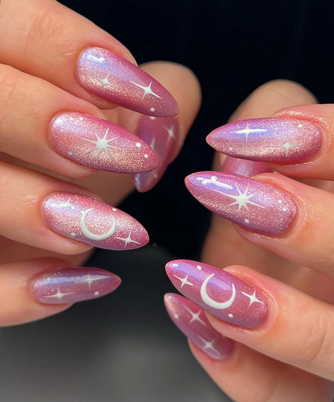 Handmade pink shimmer press-on nails with celestial crescent moon and star designs.