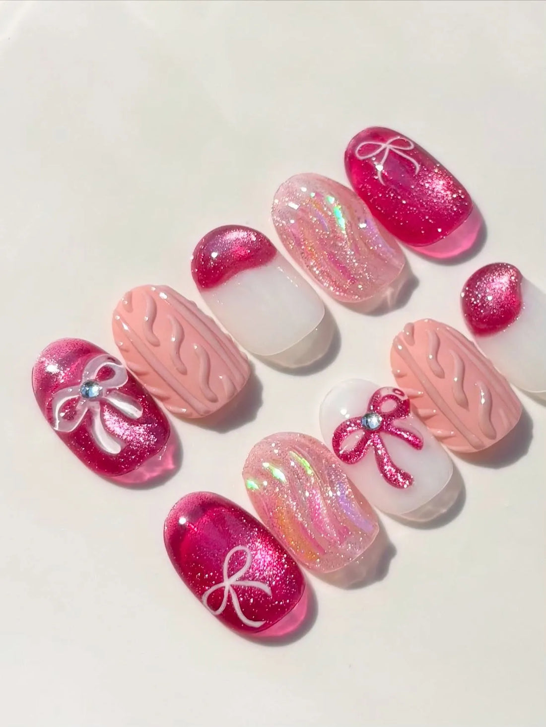 Handmade pink press-on nails with shimmer, bow, ribbon, and knit texture designs