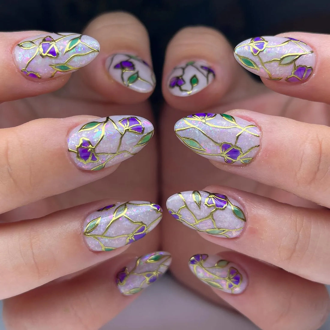 Handmade press-on nails with purple floral stained glass design and gold foil accents