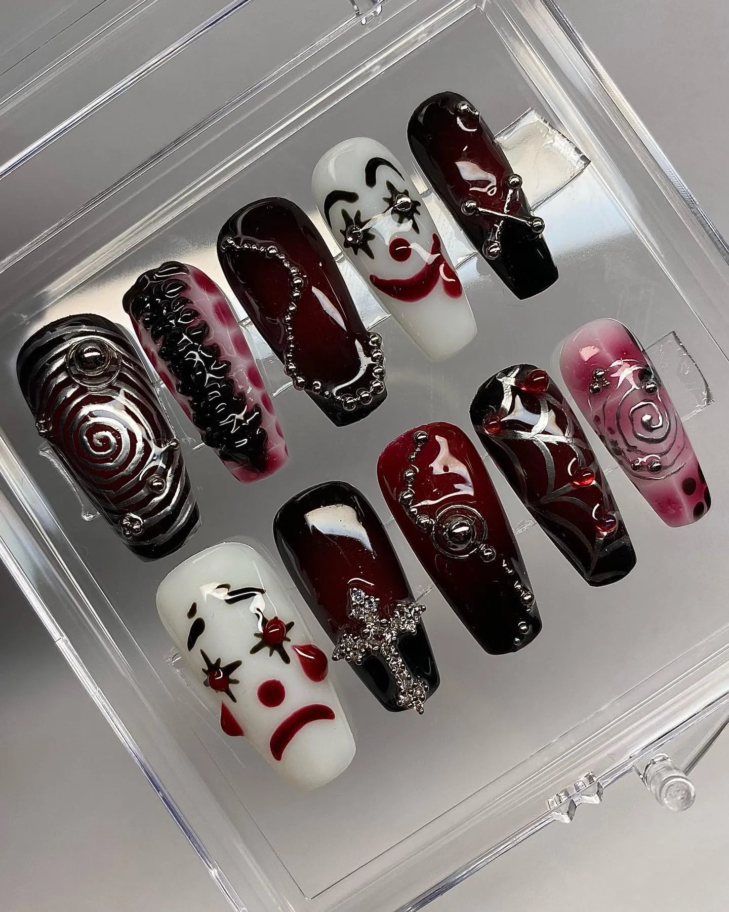 Handmade press-on nails with red, black, and white clown, grunge, and cyberpunk designs