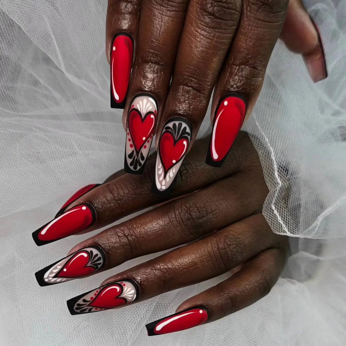 Handmade press-on nails with red heart and black gothic outline, comic style nail art.