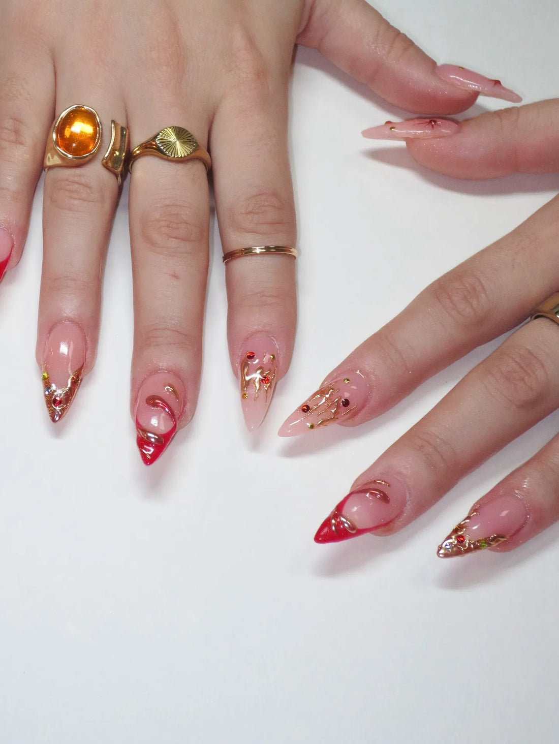 Handmade red French tip press-on nails with gold chrome drip and rhinestone accents
