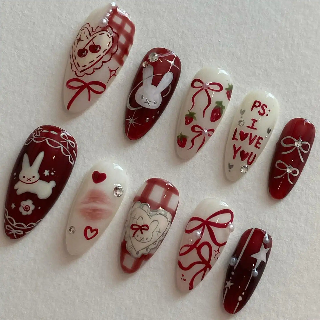 Handmade red gingham press-on nails with bunny, heart, strawberry, bow, and love letter designs