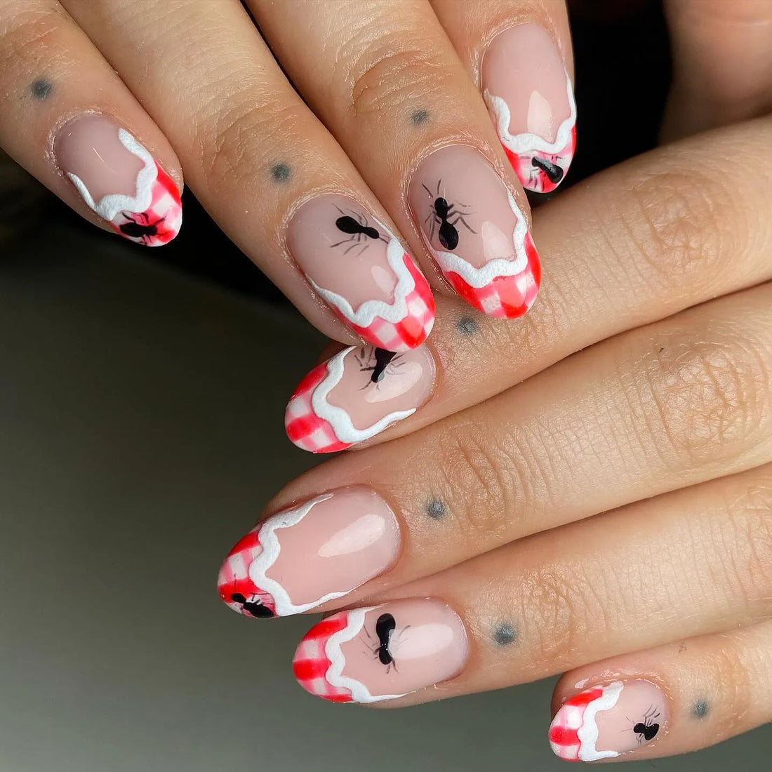 Handmade press-on nails with red gingham French tips and ant art design.