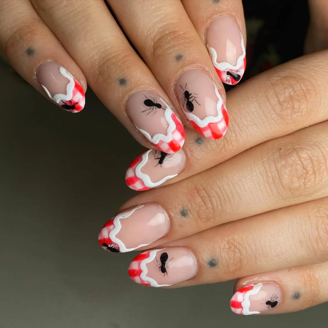 Handmade press-on nails with red gingham French tips and ant art design.