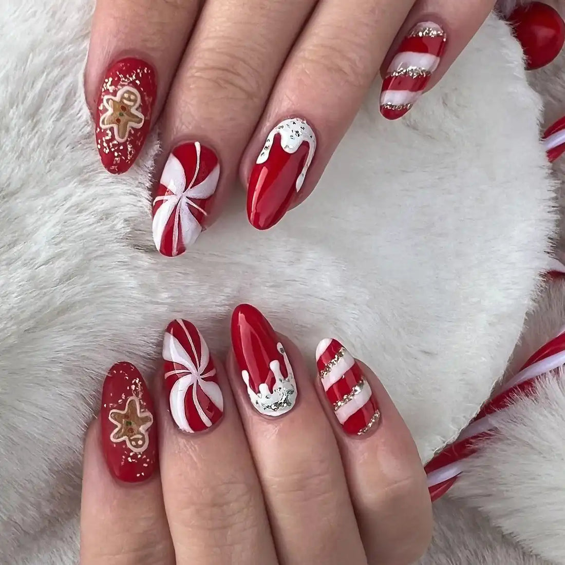 Handmade red and white Christmas press-on nails with candy cane, gingerbread, and glitter designs