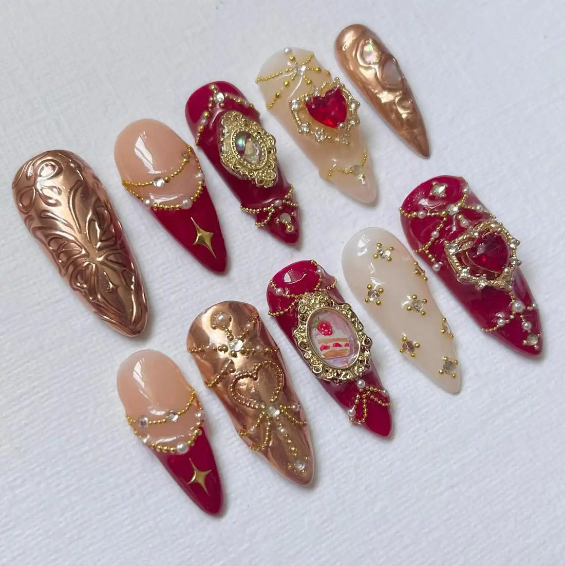 Handmade red and gold press-on nails with pearls, gems, and baroque embellished designs
