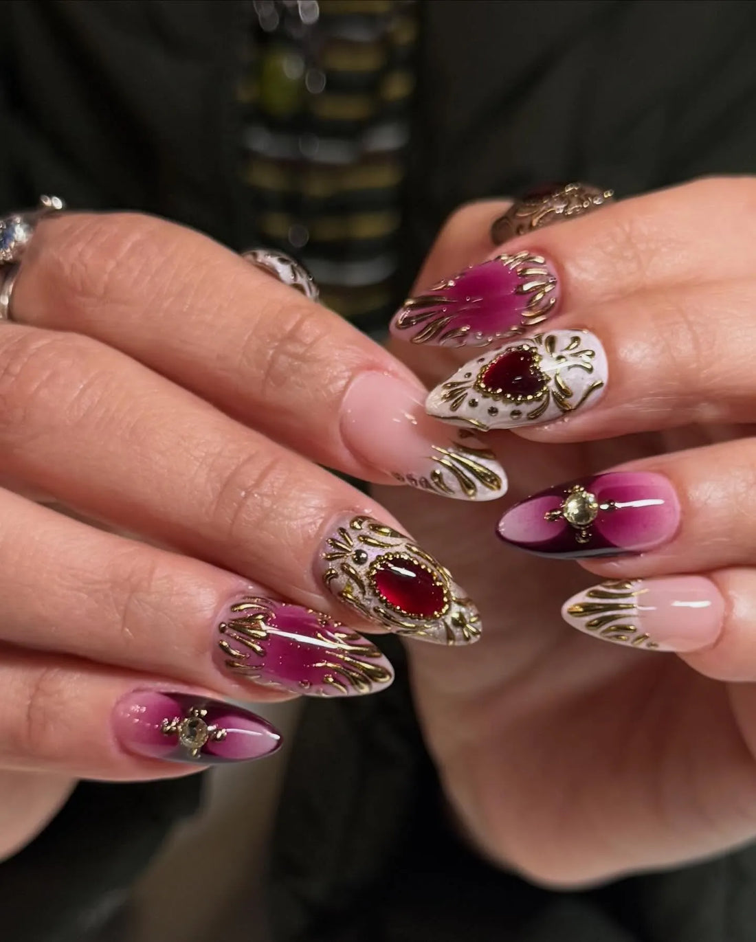 Handmade press-on stiletto nails with ruby red gemstones, gold filigree, and ombre design.