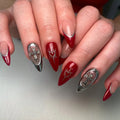 Handmade red and silver press-on nails with cross charms and heart designs, gothic style.