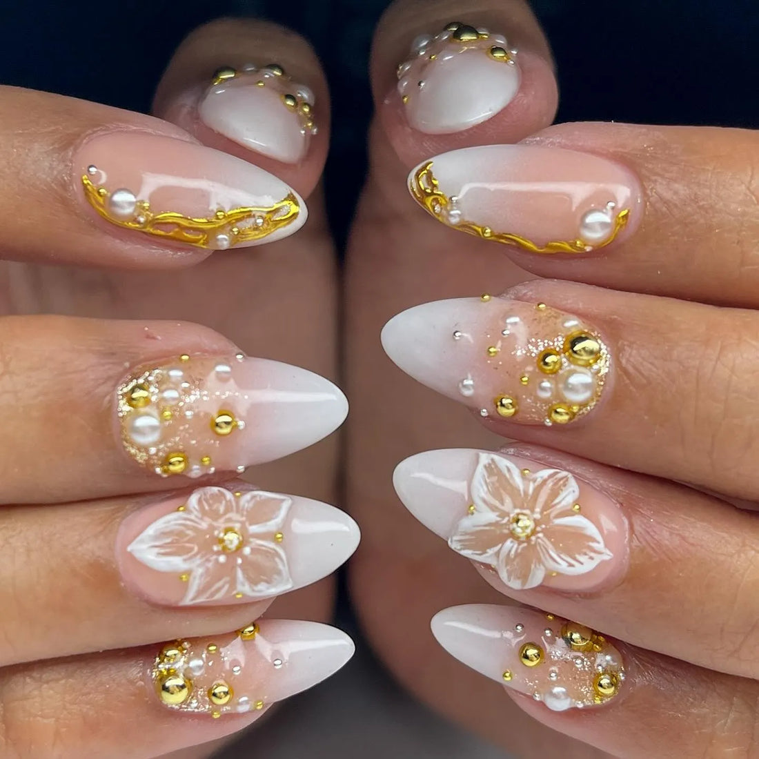 Handmade press-on nails with white floral 3D designs, gold accents, and pearl embellishments.