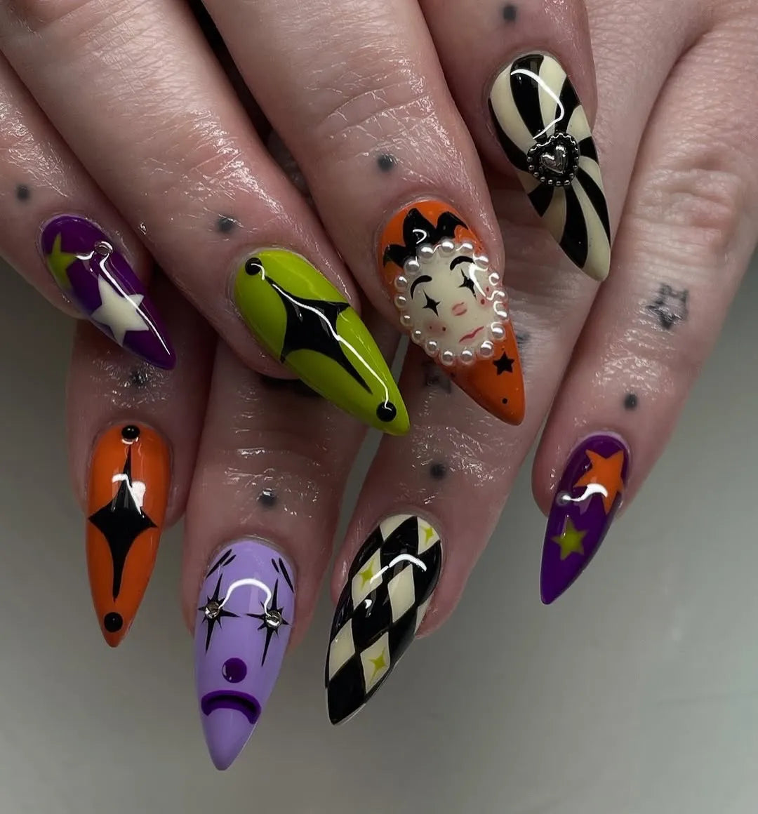 Handmade press-on nails with circus clown, harlequin, goth, and Halloween designs in vibrant colors.