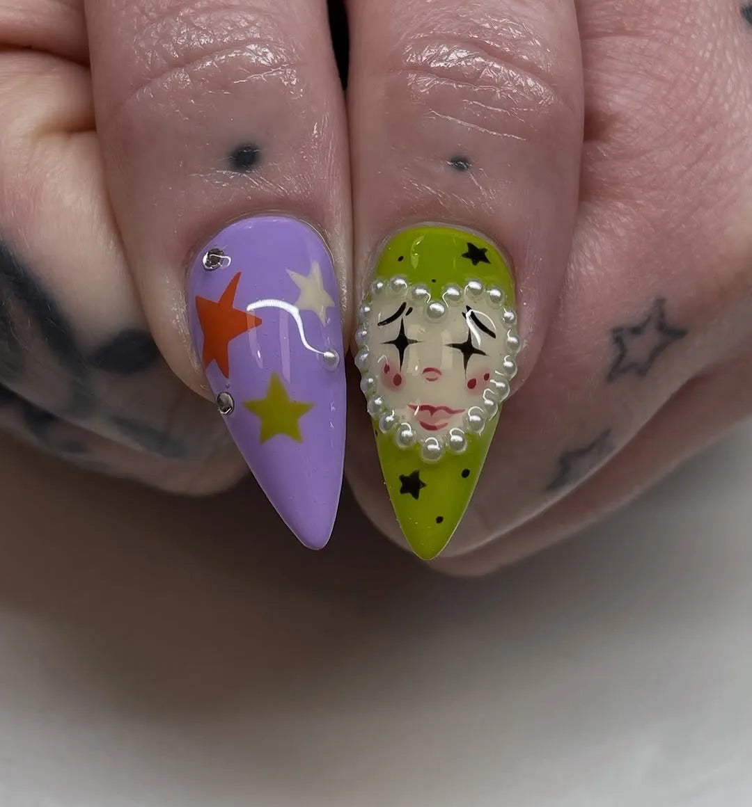 Handmade press-on nails with circus clown, harlequin, goth, and Halloween designs in vibrant colors.