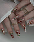 Handmade press-on nails with stained glass rose gold floral design and long stiletto shape.