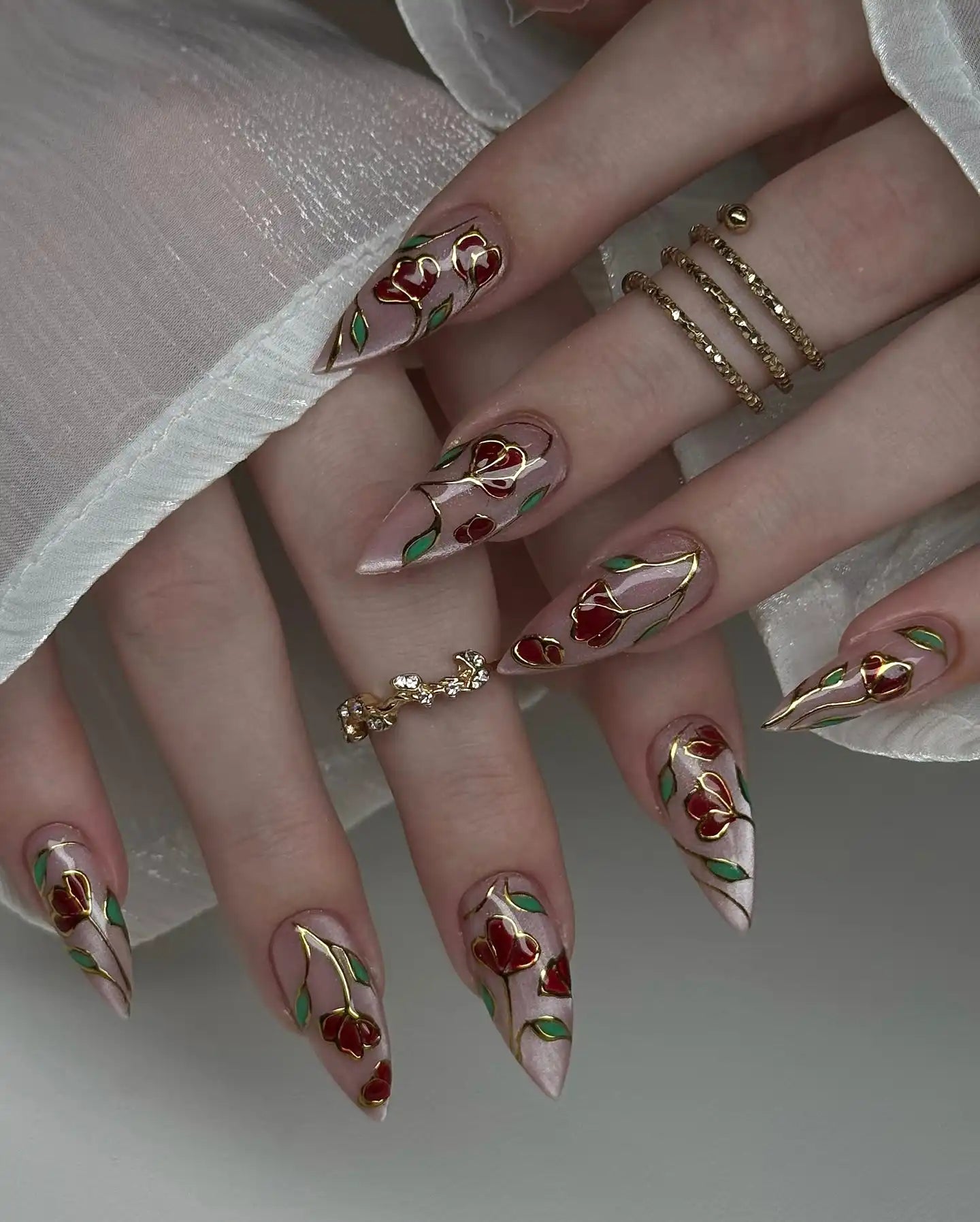 Handmade press-on nails with stained glass rose gold floral design and long stiletto shape.