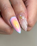Hand with handmade summer press-on nails, featuring pastel ombré, 3D droplets, and starfish embellishment.
