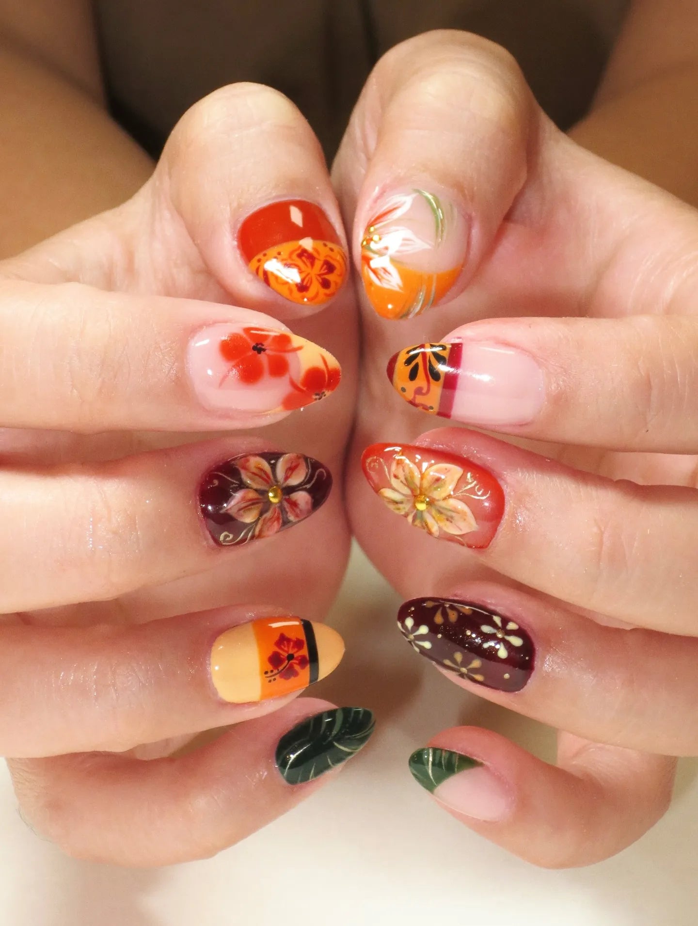 Handmade press-on nails with tropical hibiscus and autumn floral designs in multiple colors.