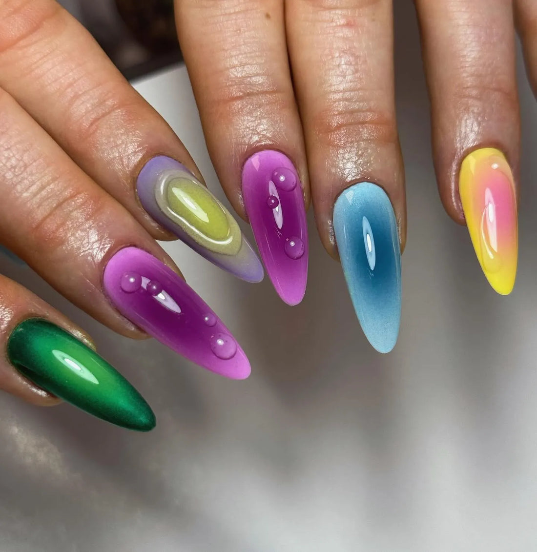 Handmade press-on nails with vibrant rainbow chrome and liquid drip design