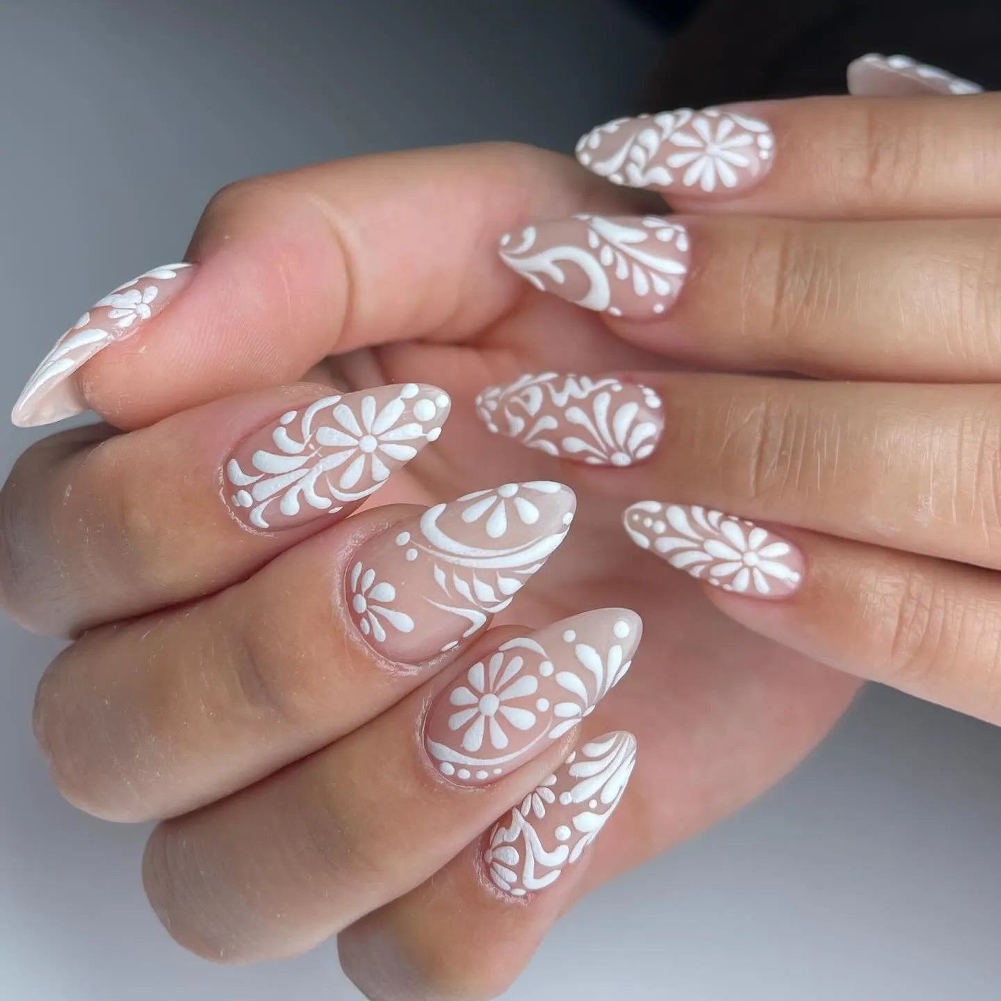 Handmade white lace floral swirl press-on nails with elegant bridal nail art.