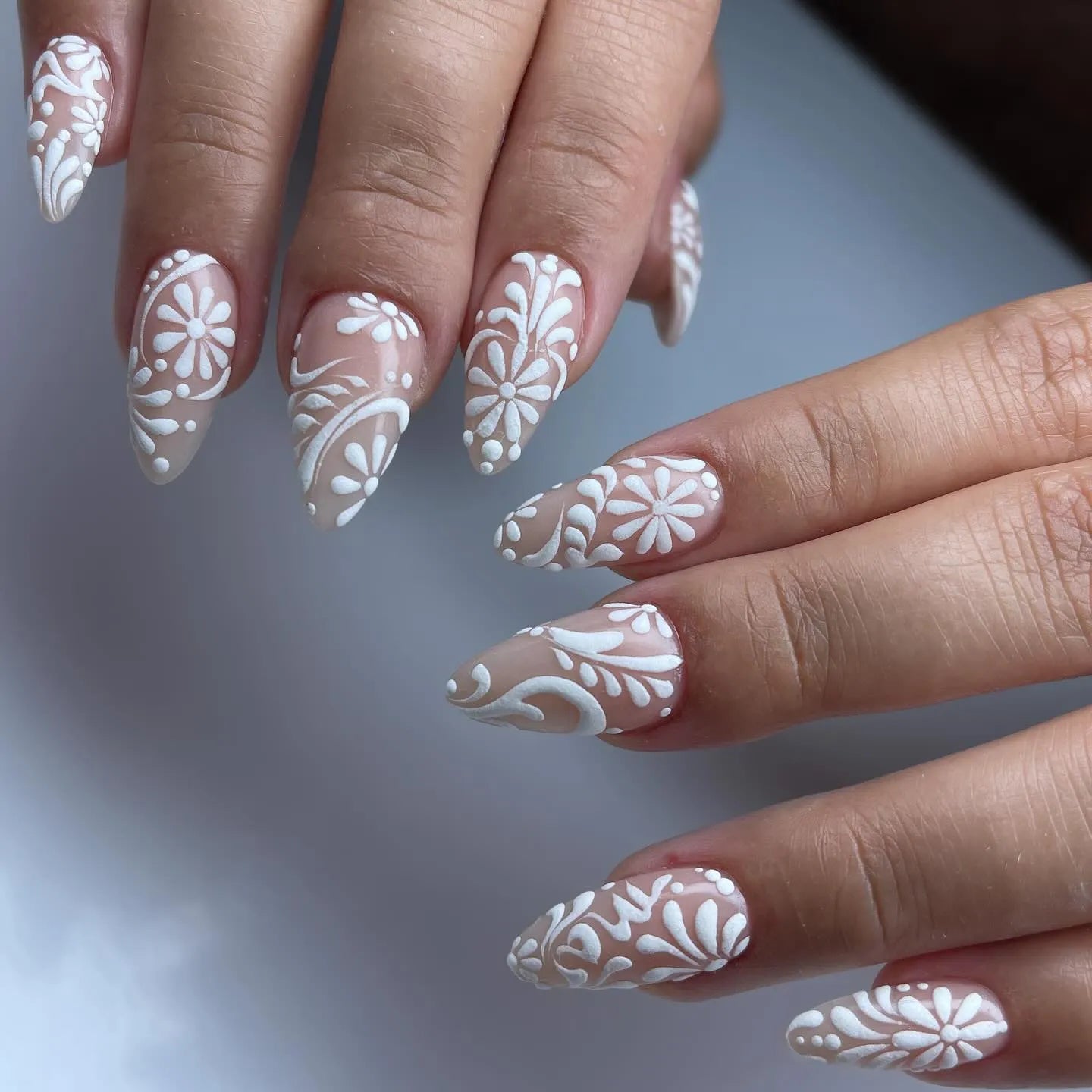 Handmade white lace floral swirl press-on nails with elegant bridal design on almond shape tips