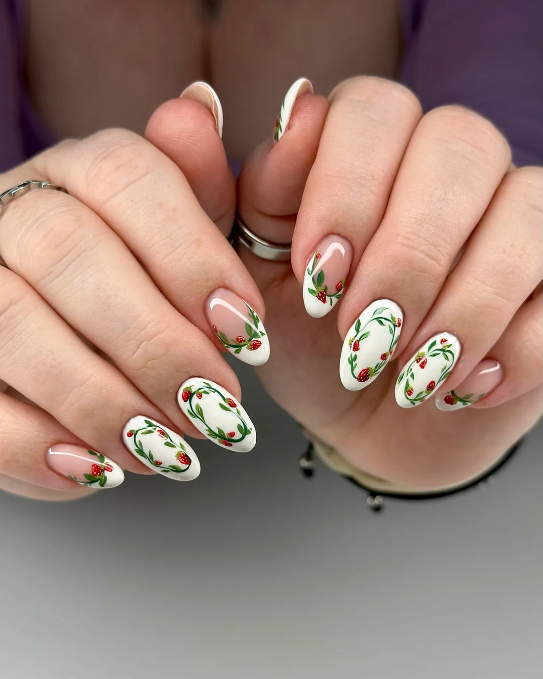 Handmade white and nude press-on nails with painted strawberry wreath nail art.