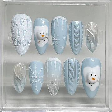 Handmade blue winter press-on nails with snowman, snowflake, icicle and sweater designs.